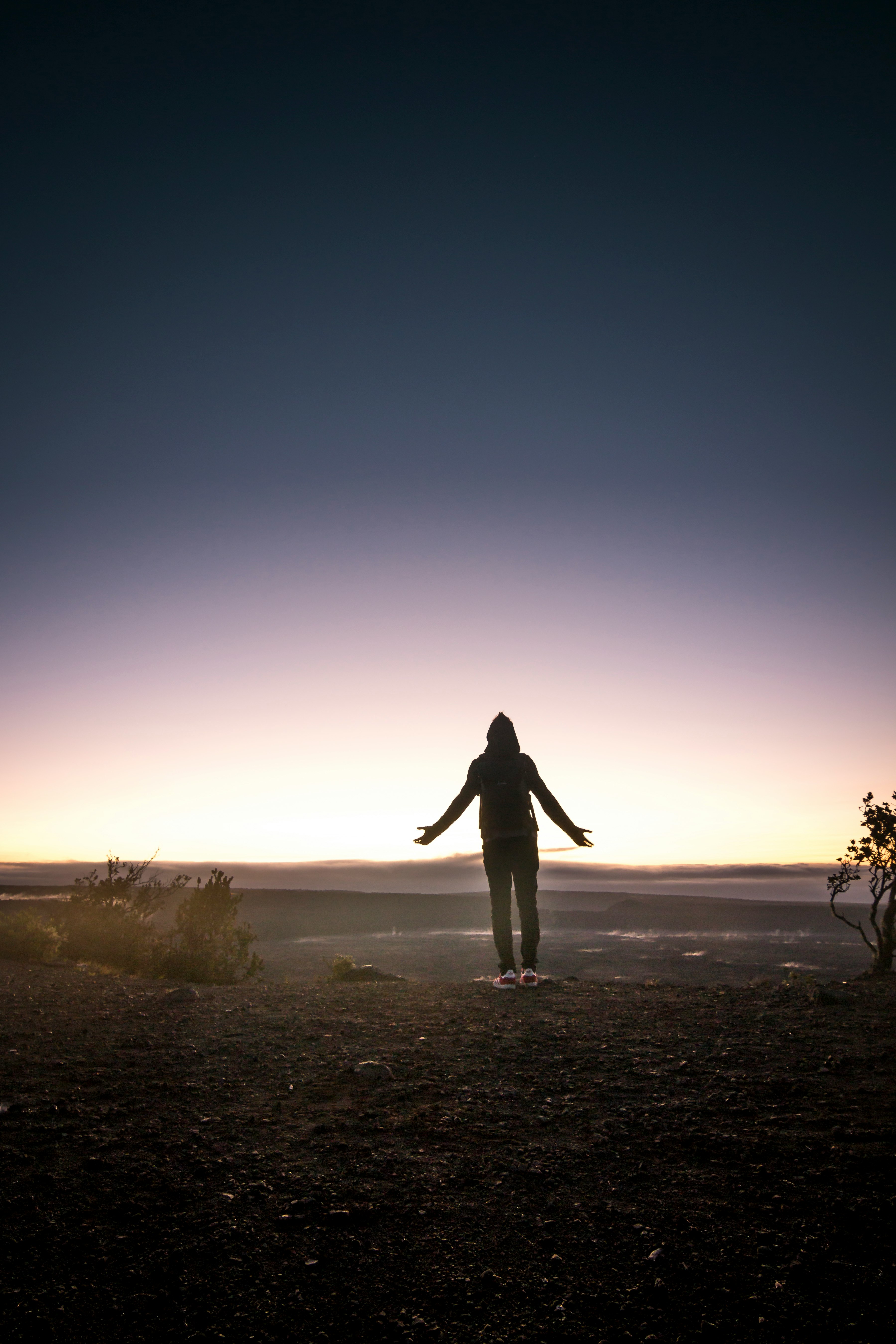 silhouette of person standing on mountain top